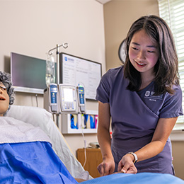 Student practicing patient care with a manikin