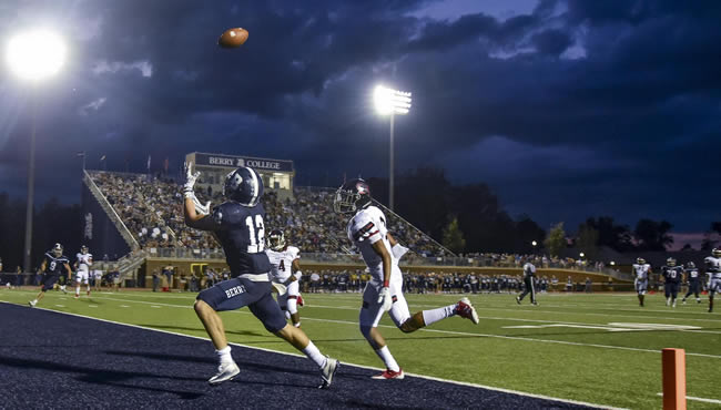 Berry football players catching a football