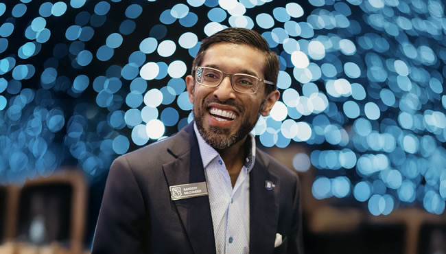 President Mazumder against a background of blue bokeh lights