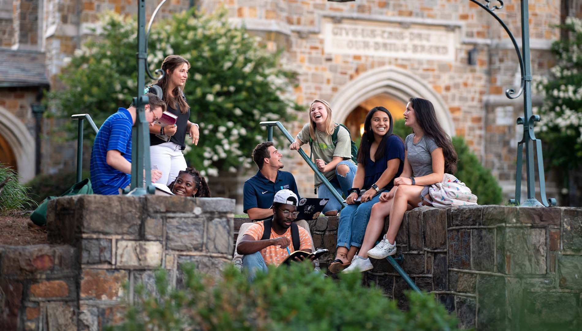 diverse group of students laughing on stone steps