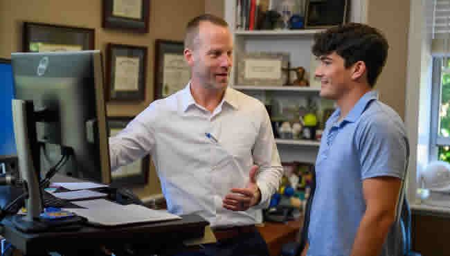 A student and a faculty mentor at a computer.