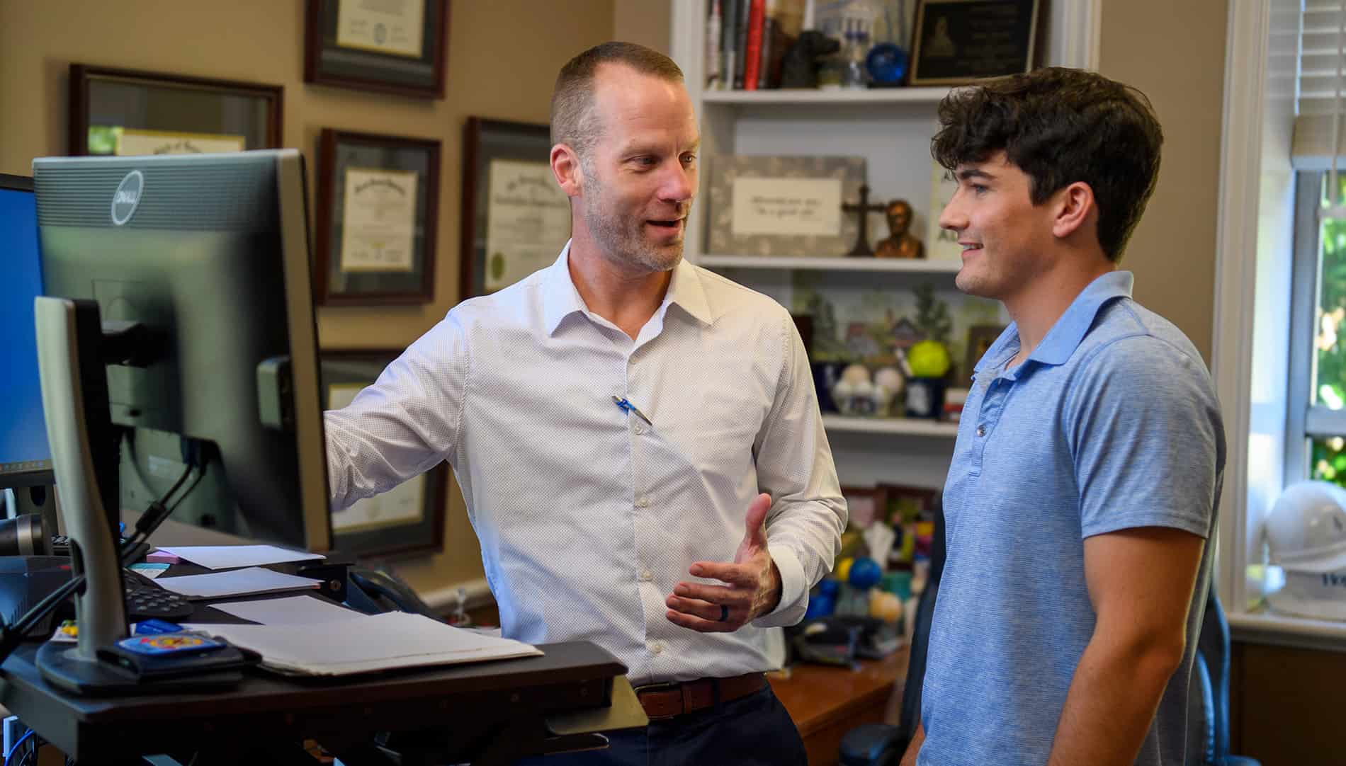 A student and a faculty mentor at a computer.
