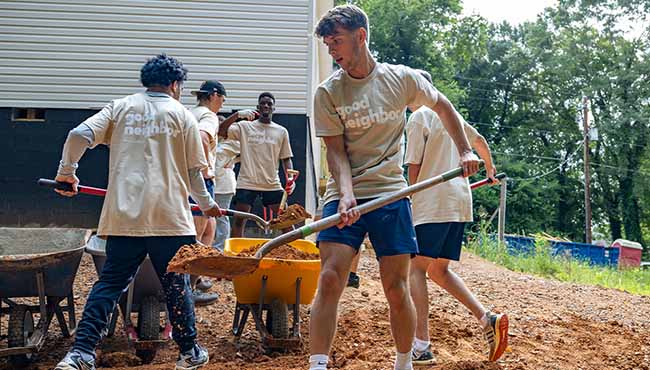 Group of students shoveling dirt
