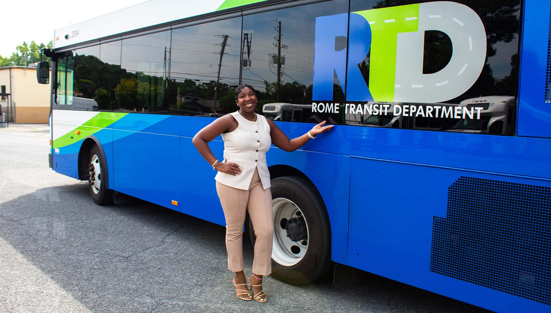 Courtnay Griffin smiling while standing next to a Rome Transit Department bus