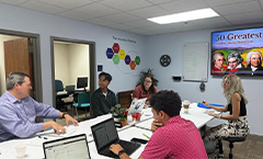 Group of students and professors talking around a table